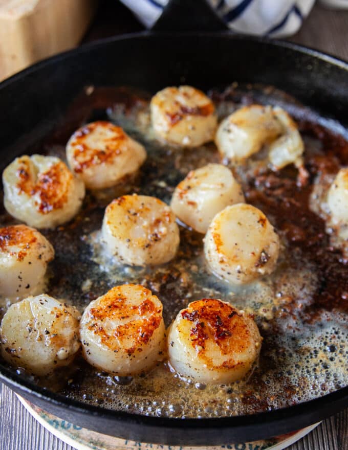 Golden brown perfectly seared scallops in the hot pan